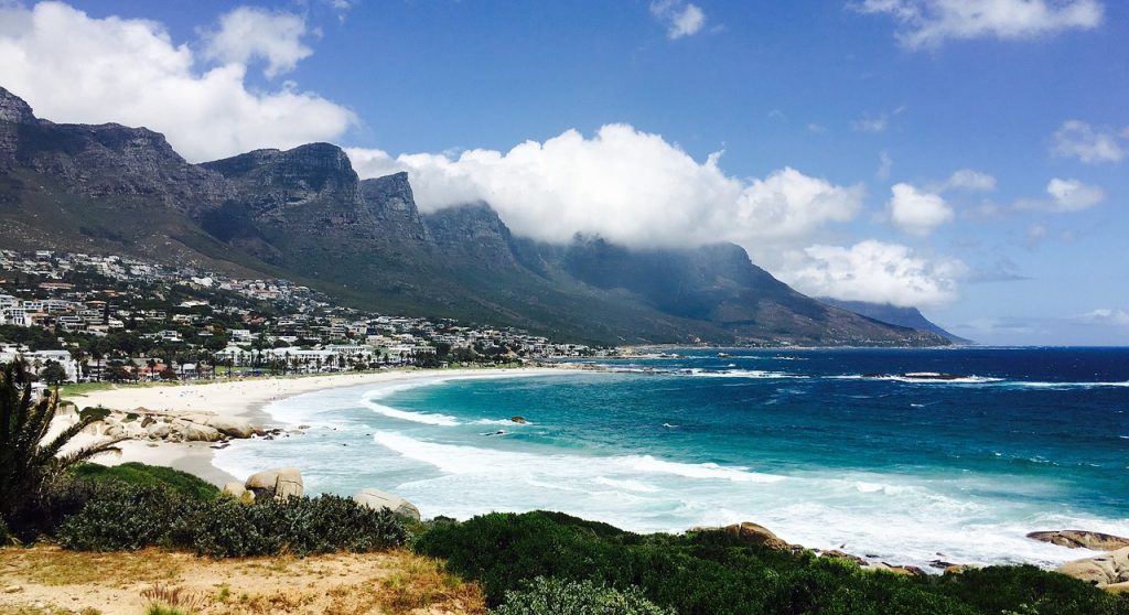 Ocean bay beach with houses and mountains